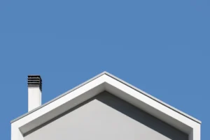 A white roof with a chimney and a blue sky