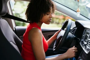 A woman sitting in the driver 's seat of her car.