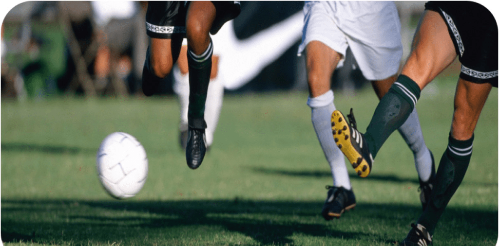 A group of people kicking around a soccer ball.