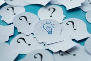 A pile of question marks with one light bulb on top.