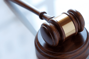A wooden judge 's gavel on top of a table.