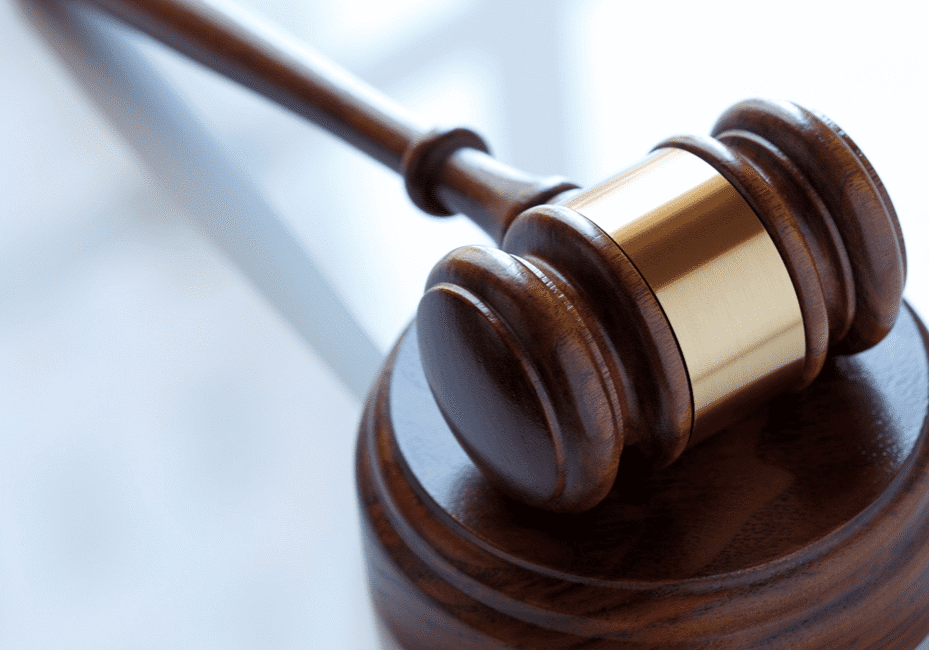 A wooden judge 's gavel on top of a table.