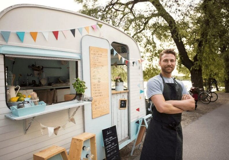 A man standing in front of a food truck.