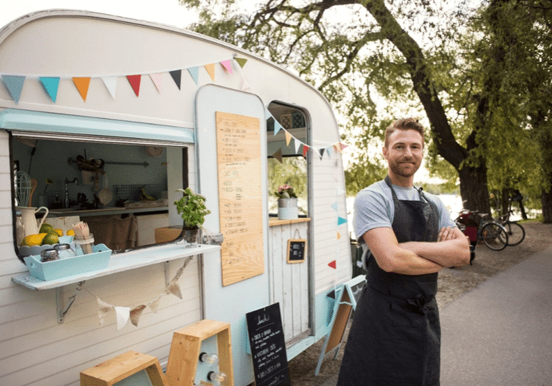 A man standing in front of a food truck.