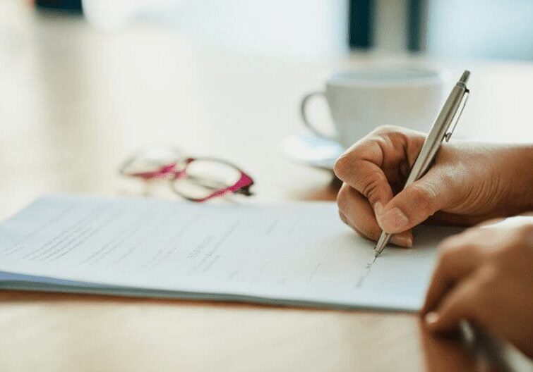 Hand signing document with a pen. - 27123
