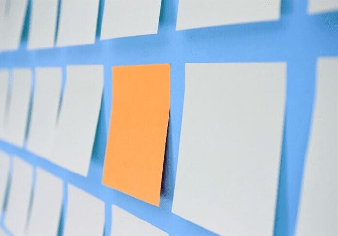 A yellow sticky note stuck to the side of a wall.
