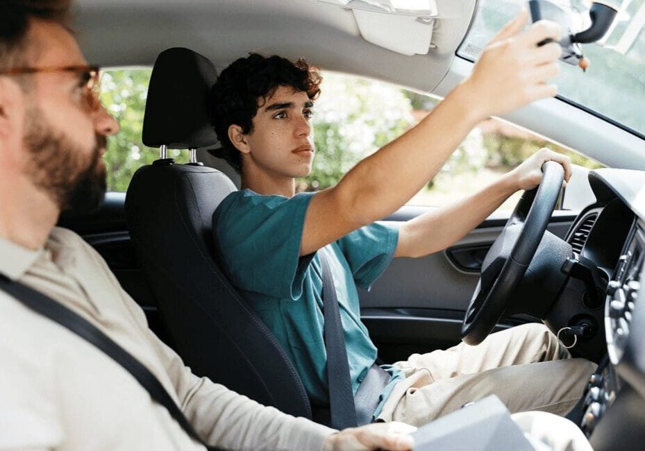 A man driving in the back of a car.