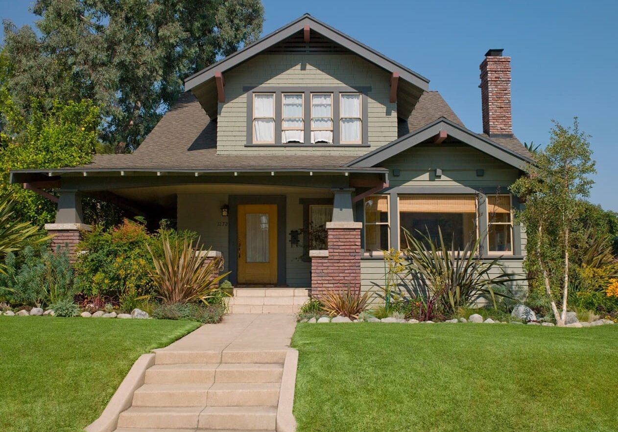 A house with grass and bushes around it.