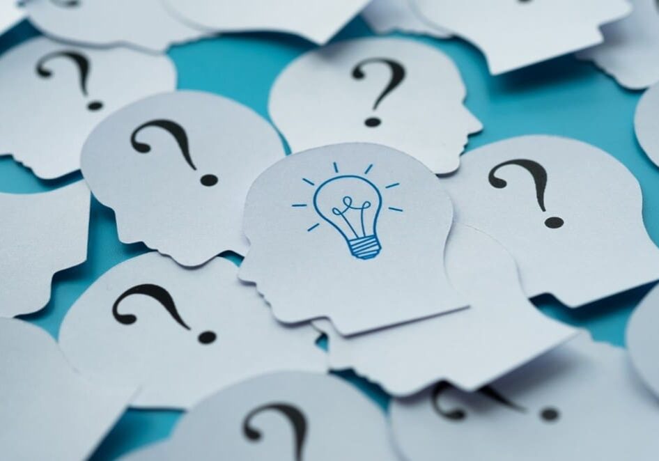 A pile of question marks with one light bulb on top.